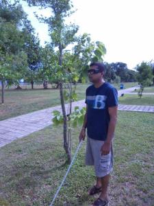 Dushyantha walking in the garden with the help of ultra sonic glassess and white cane